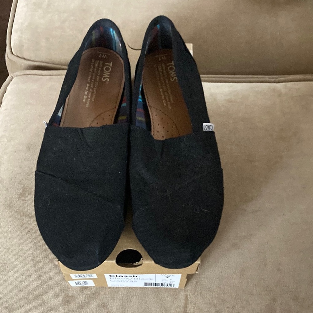 Tom’s black canvas shoes